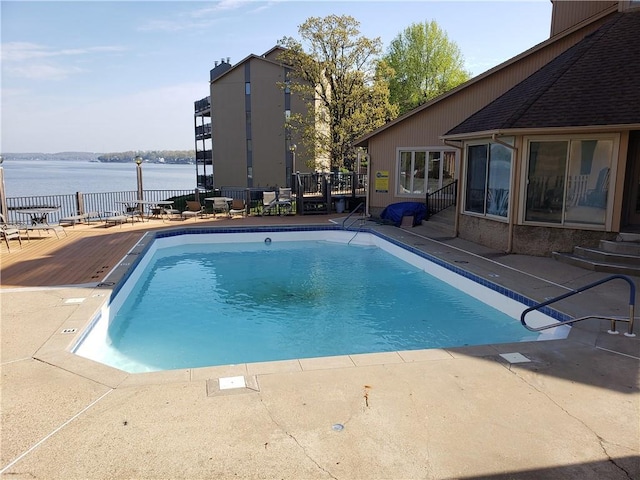 view of pool featuring a patio area and a water view