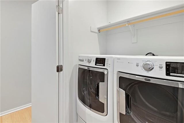 laundry area featuring light wood-type flooring, laundry area, and washer and dryer