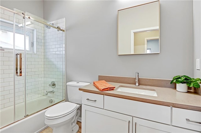 full bath featuring toilet, bath / shower combo with glass door, and vanity