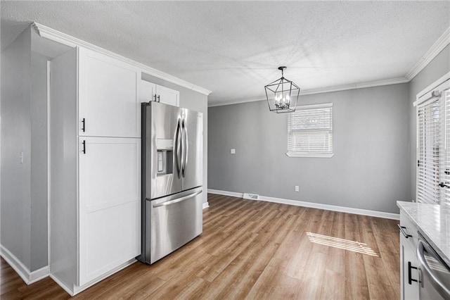 kitchen featuring stainless steel appliances, white cabinetry, light wood-style floors, and ornamental molding