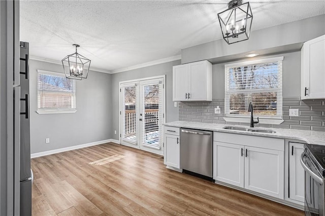 kitchen with a chandelier, light wood-style flooring, a sink, white cabinetry, and appliances with stainless steel finishes