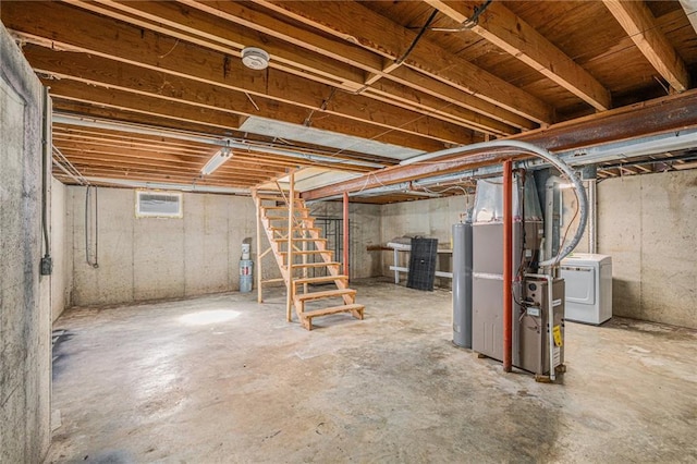 basement featuring water heater and washer / dryer