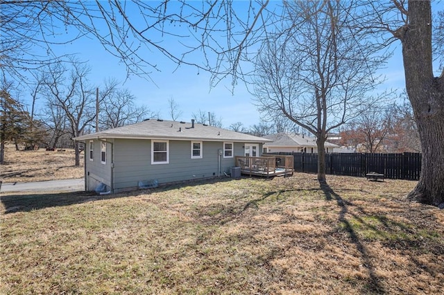 rear view of property featuring a yard, fence, and a wooden deck