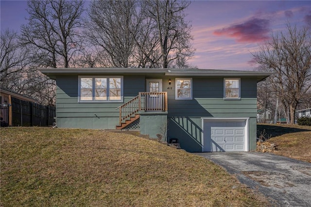 view of front of home with a garage, a front lawn, and aphalt driveway