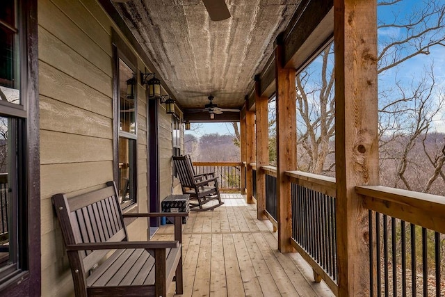 wooden terrace with ceiling fan and covered porch