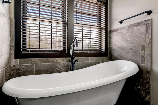 bathroom with tile walls, sink, and a tub