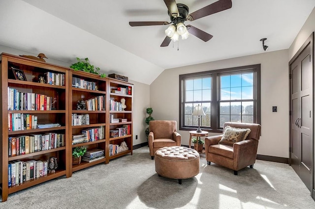 living area with lofted ceiling, light colored carpet, and ceiling fan