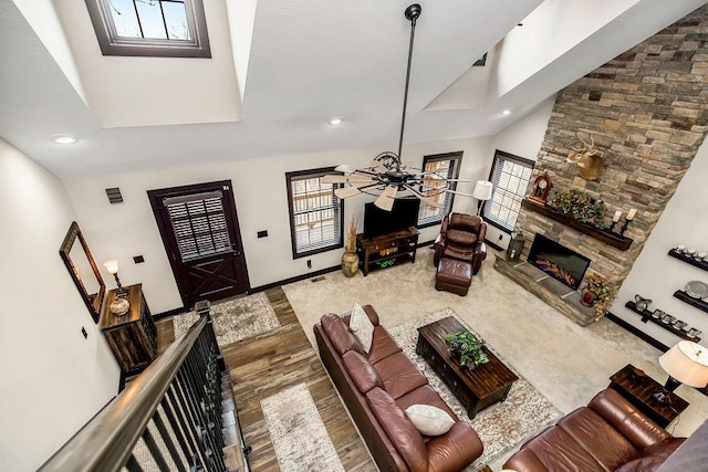 living room featuring hardwood / wood-style flooring, a stone fireplace, plenty of natural light, and ceiling fan