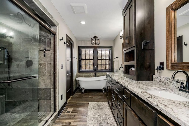 bathroom featuring hardwood / wood-style flooring, vanity, and separate shower and tub