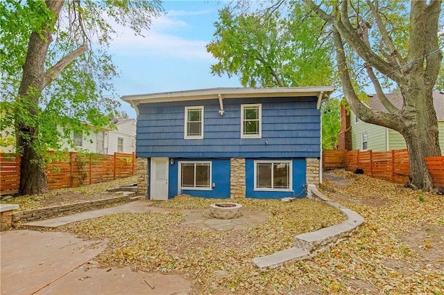 rear view of property featuring an outdoor fire pit