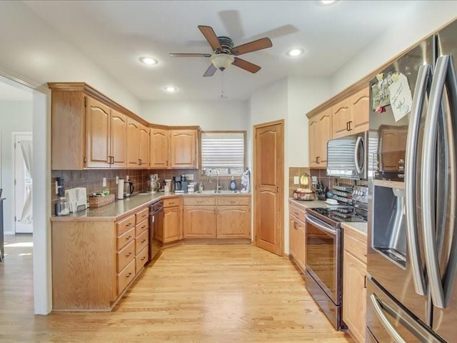 kitchen featuring tasteful backsplash, ceiling fan, stainless steel appliances, and light hardwood / wood-style flooring