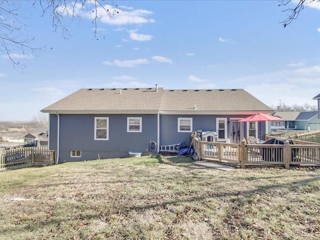 rear view of property featuring a lawn and a deck