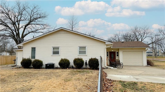 view of front of house with a garage, a front yard, and central AC unit