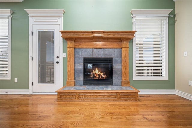 room details with a tiled fireplace and hardwood / wood-style floors