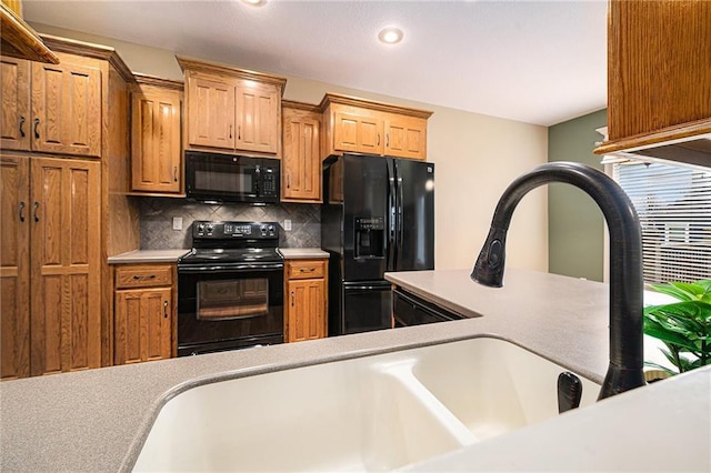 kitchen featuring black appliances, light countertops, backsplash, and recessed lighting