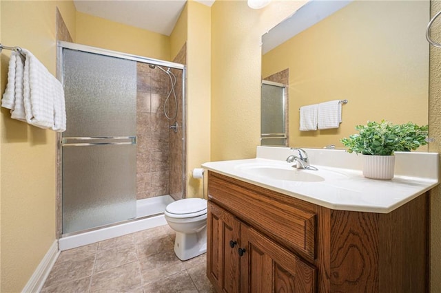 bathroom with vanity, tile patterned flooring, a shower with door, and toilet