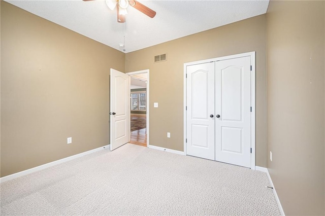 unfurnished bedroom featuring light carpet, baseboards, visible vents, and a closet