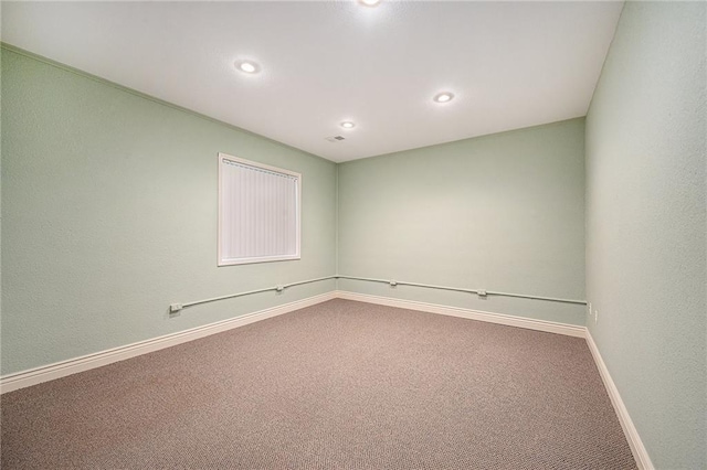 carpeted empty room featuring baseboards and recessed lighting