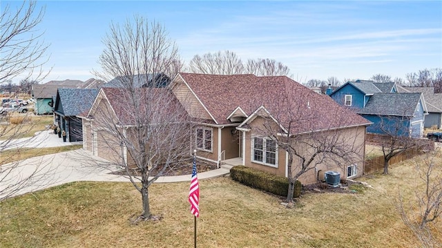 view of front of property with a garage, central AC, and a front yard