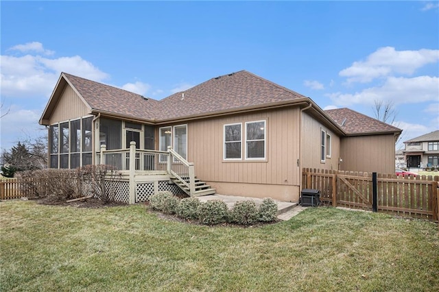 back of house with a sunroom, a fenced backyard, and a yard