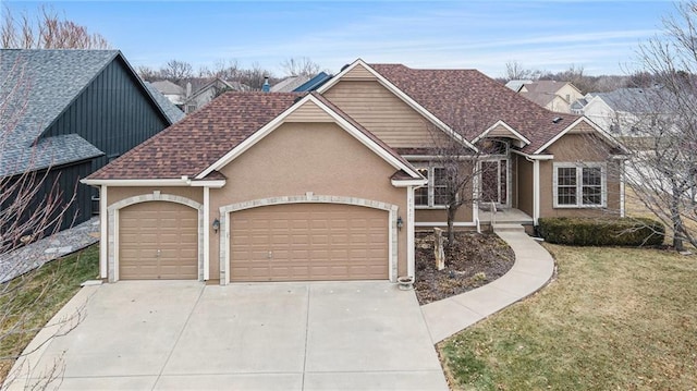 view of front facade featuring a garage, concrete driveway, roof with shingles, a front lawn, and stucco siding