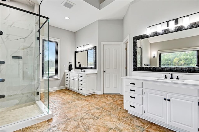 bathroom with vanity, a wealth of natural light, and a shower with shower door