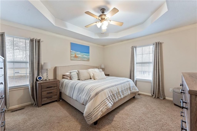 bedroom with crown molding, light colored carpet, a raised ceiling, and ceiling fan