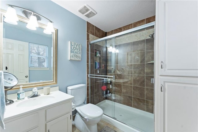 bathroom featuring vanity, toilet, and a shower with shower door