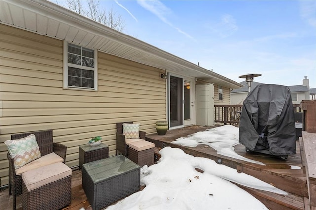 snow covered patio with an outdoor living space and a deck