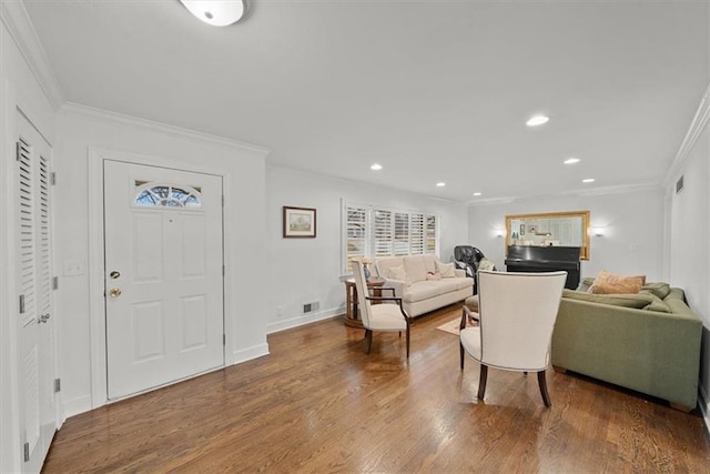 foyer entrance with crown molding and wood-type flooring