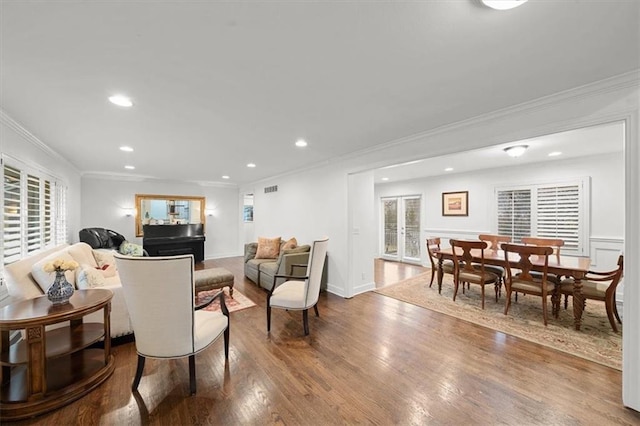 living room with hardwood / wood-style flooring, crown molding, and french doors