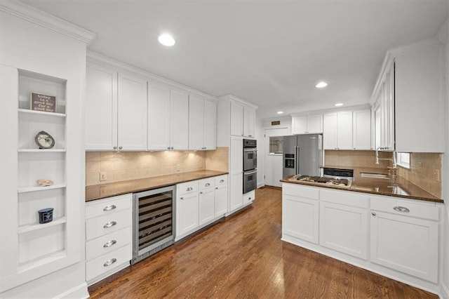 kitchen featuring white cabinets, appliances with stainless steel finishes, dark hardwood / wood-style floors, and beverage cooler