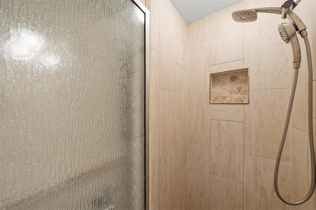 interior details featuring tiled shower