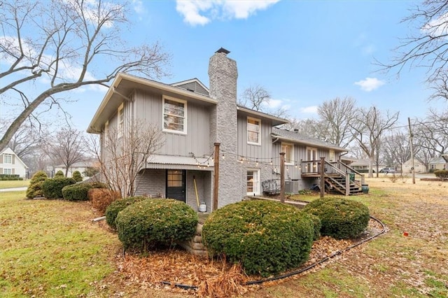 back of house featuring a wooden deck and a lawn