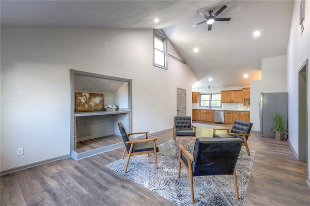 living room with a fireplace, dark wood-type flooring, high vaulted ceiling, and ceiling fan