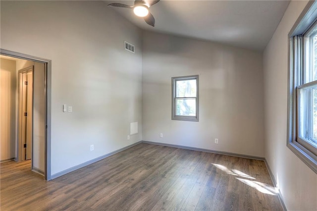 empty room with dark wood-type flooring, ceiling fan, and vaulted ceiling