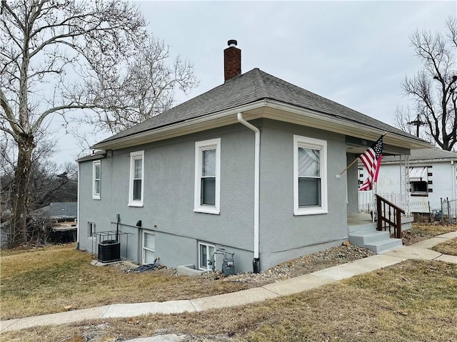 view of side of home featuring a yard and central AC unit