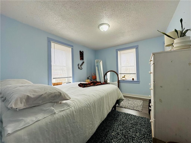 bedroom featuring hardwood / wood-style flooring and a textured ceiling