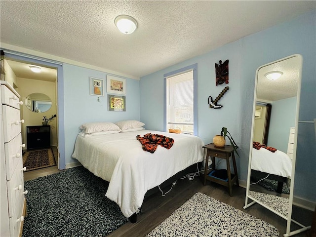 bedroom with dark hardwood / wood-style flooring and a textured ceiling