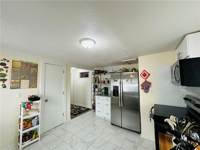 kitchen featuring white cabinetry, stainless steel appliances, and a textured ceiling