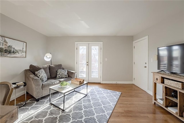 living area with french doors, baseboards, and wood finished floors