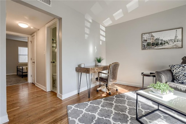 office area featuring visible vents, baseboards, and wood finished floors