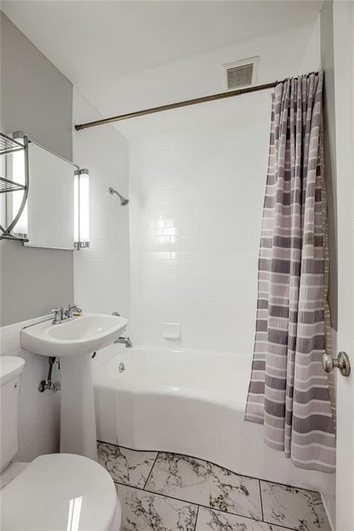 bathroom with visible vents, toilet, and shower / bath combo with shower curtain