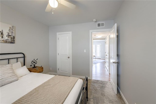 carpeted bedroom featuring visible vents, baseboards, and a ceiling fan