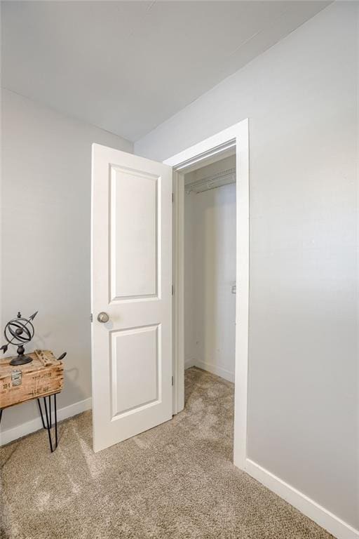 bedroom featuring light colored carpet and baseboards