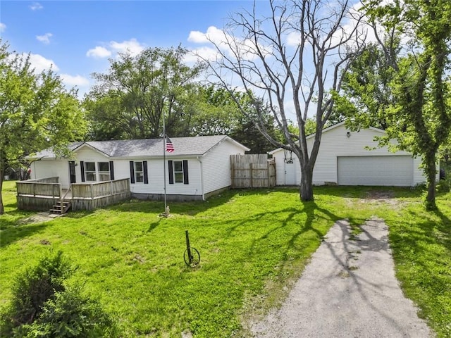 rear view of house with a deck, driveway, and an outdoor structure