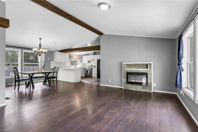 living room with a chandelier, dark wood finished floors, and healthy amount of natural light