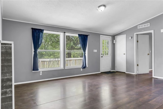 entryway with vaulted ceiling, wood finished floors, a textured ceiling, ornamental molding, and baseboards