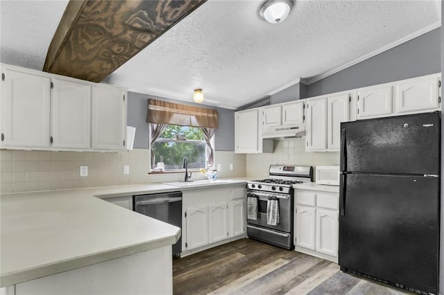 kitchen with appliances with stainless steel finishes, lofted ceiling, a textured ceiling, under cabinet range hood, and dark wood finished floors