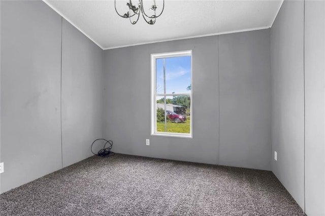 spare room featuring carpet, a chandelier, and ornamental molding